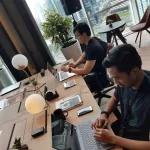 Tim hybrid berdiskusi melalui video call dan mencatat ide di papan digital bersama