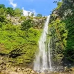 "Air terjun Coban Rondo yang menjulang tinggi di tengah hutan pegunungan Batu, Malang