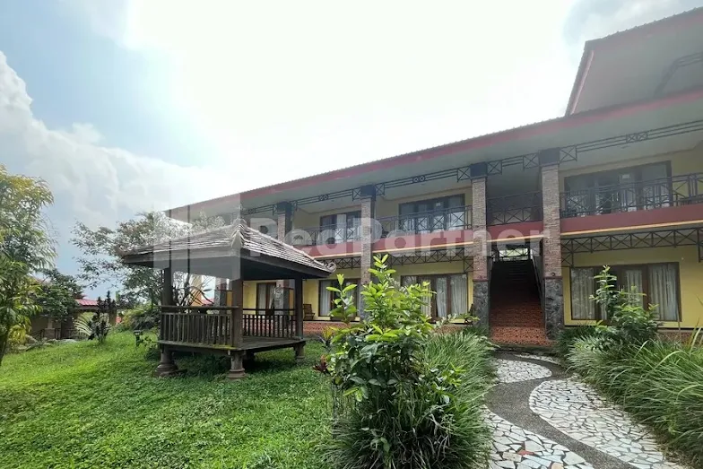 Pemandangan pegunungan dari kolam renang Grand Pujon View, tempat gathering Malang yang sejuk.