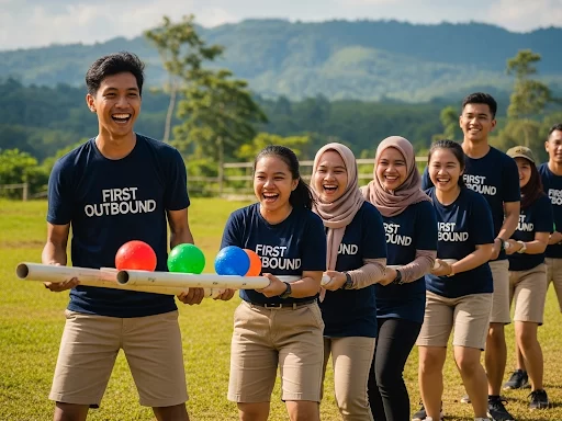 Tim perusahaan sedang melakukan kegiatan outbound team building yang seru di lapangan luas Lembah Indah Malang.