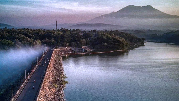 sunrise di waduk selorejo malang dengan kabut tipis dan cahaya keemasan